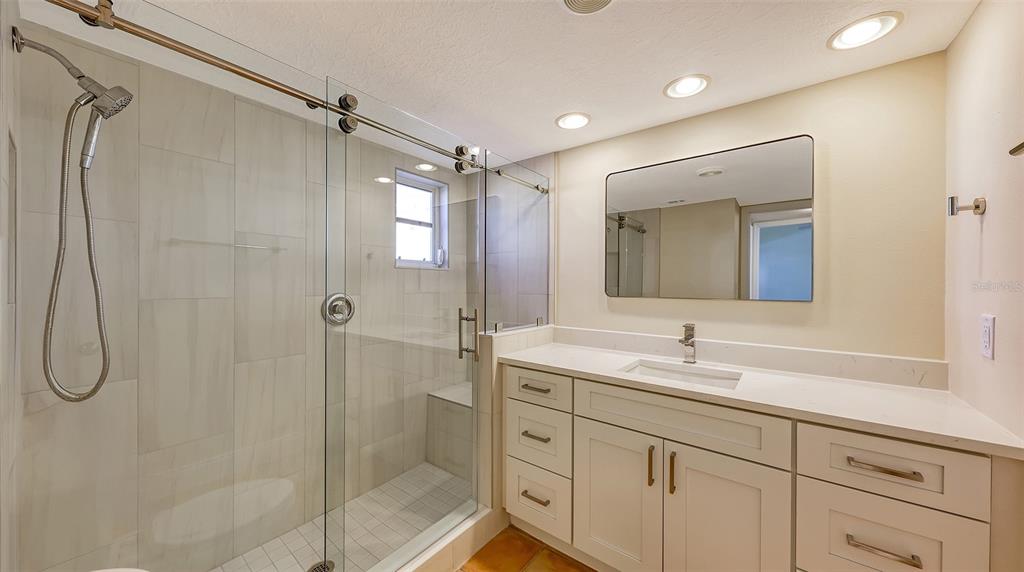 5860 Midnight Pass Road, Unit 40 Sarasota, FL 34242 - Photo 15 of 37 a bathroom with a double vanity sink mirror and shower