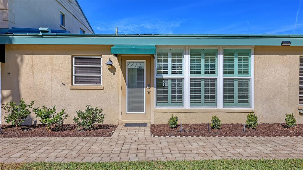 5860 Midnight Pass Road, Unit 40 Sarasota, FL 34242 - Photo 21 of 37 a front view of a house with a yard