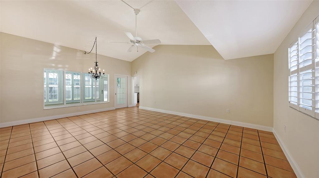 5860 Midnight Pass Road, Unit 40 Sarasota, FL 34242 - Photo 9 of 37 an empty room with windows and chandelier fan