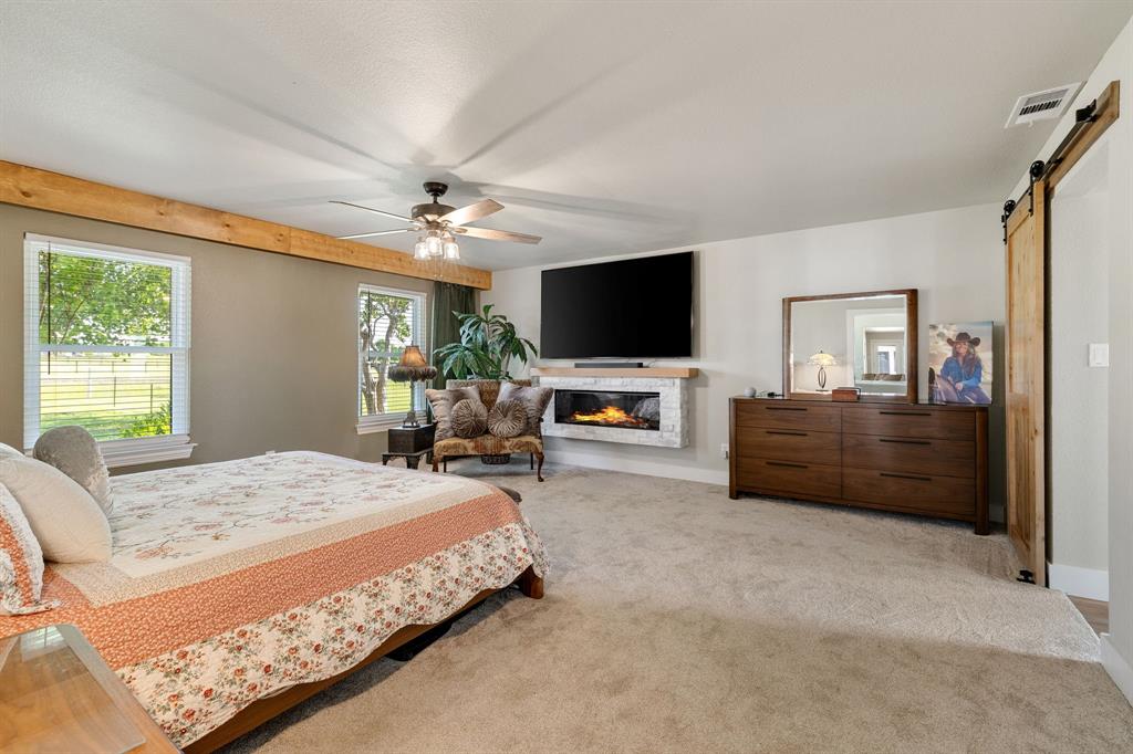 12240 Wellington Road Ponder, TX 76259 - Photo 22 of 40 Spacious room featuring light carpet flooring, a ceiling fan, and a wood-beam accent