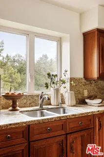 a bathroom with a granite countertop sink and a large mirror