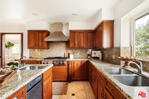 a kitchen with stainless steel appliances granite countertop a sink stove and cabinets