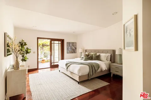 a spacious bedroom with a large bed and a potted plant