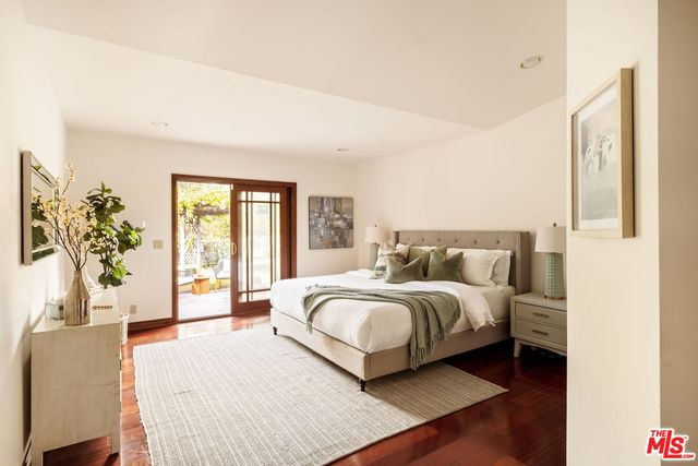 a spacious bedroom with a large bed and a potted plant