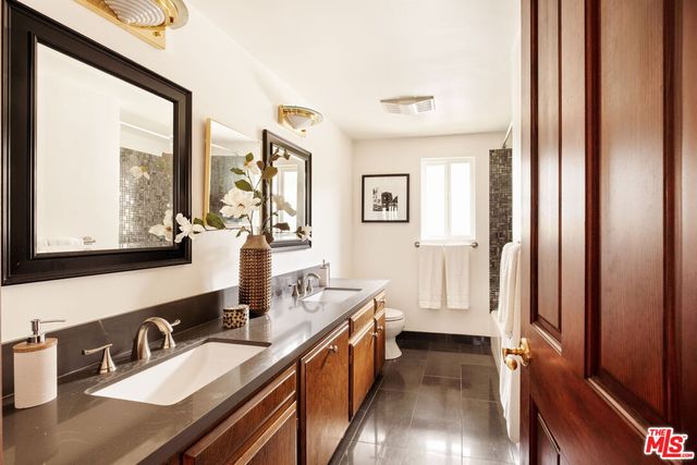 a bathroom with a double vanity sink a mirror and a bathtub