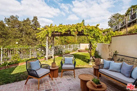 a roof deck with table and chairs and potted plants