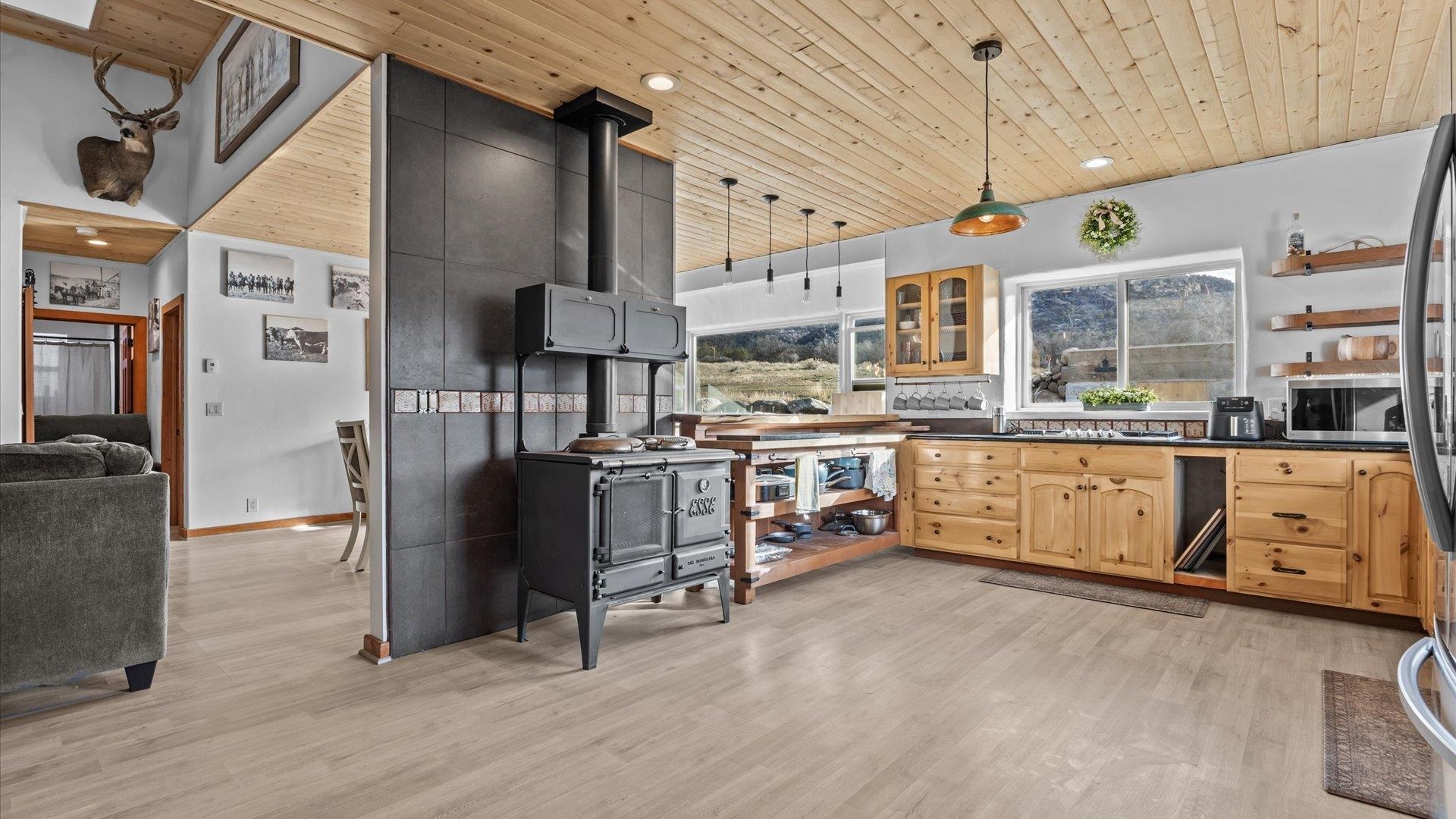 10795 52 52 1/2 Road Molina, CO 81646 - Photo 12 of 41 a kitchen with stainless steel appliances kitchen island granite countertop a stove a sink dishwasher and white cabinets with wooden floor