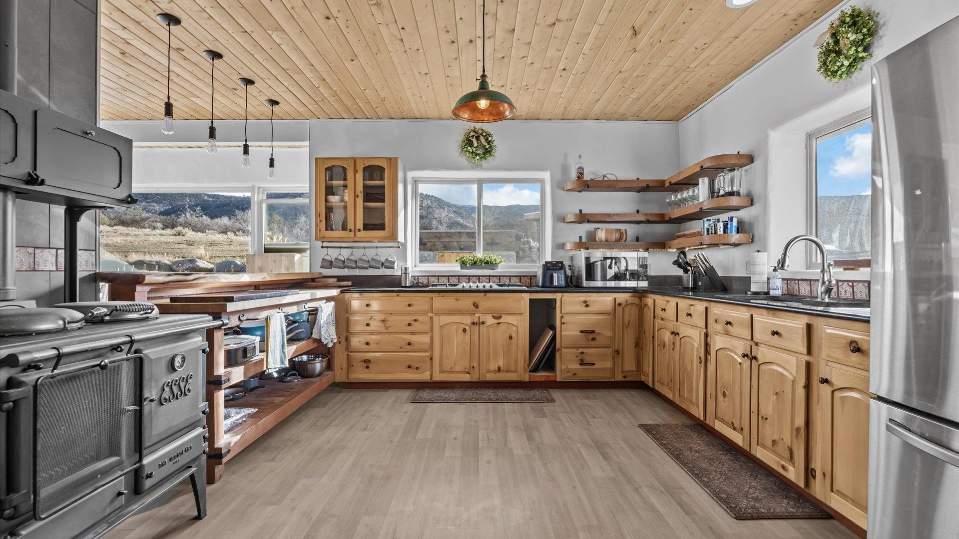 10795 52 52 1/2 Road Molina, CO 81646 - Photo 22 of 41 a kitchen with stainless steel appliances granite countertop a stove a sink dishwasher and white cabinets with wooden floor