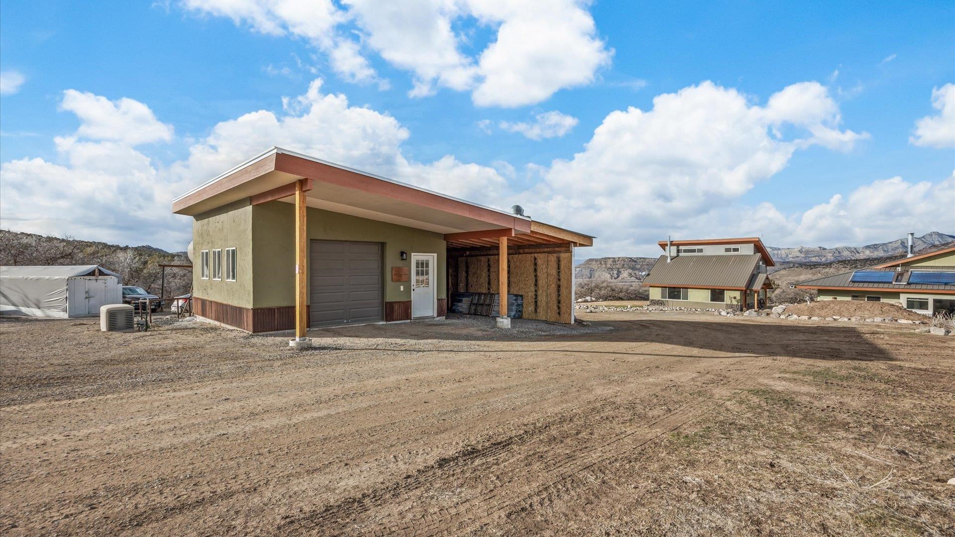 10795 52 52 1/2 Road Molina, CO 81646 - Photo 25 of 41 a front view of a house with a yard and garage