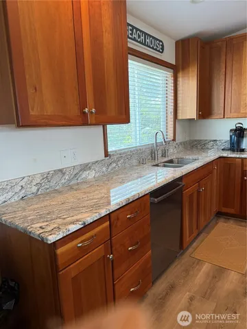 a kitchen with granite countertop cabinets sink and window