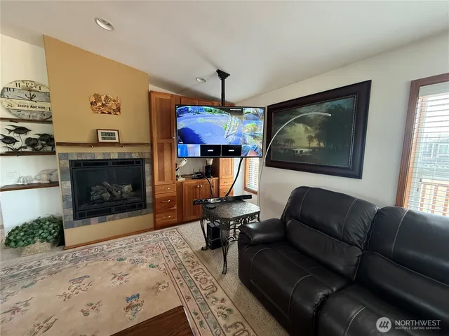 a living room with furniture a fireplace and a flat screen tv