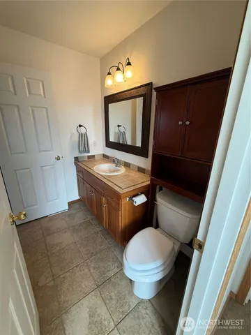 a bathroom with a toilet mirror vanity and tub