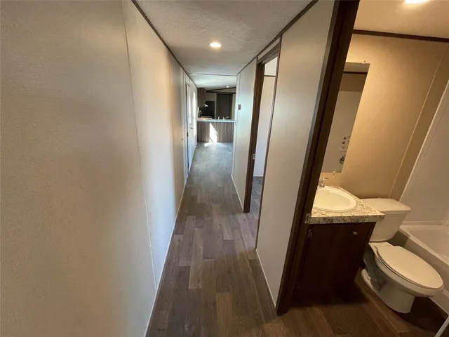 a view of a hallway and a livingroom with furniture