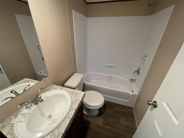 a white toilet sitting next to a bathroom sink and tub