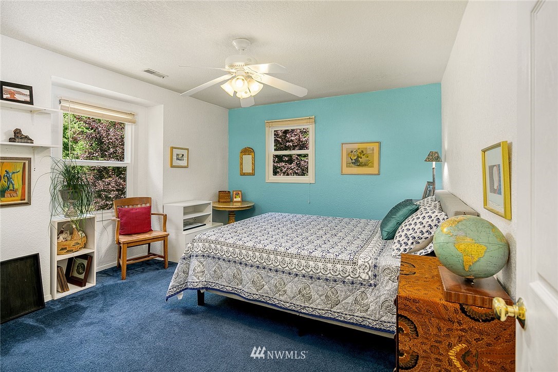 17905 Beall Road Southwest Vashon, WA 98070 - Photo 11 of 20 a bedroom with a bed and a chandelier