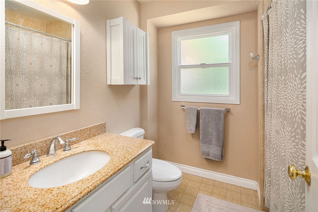 17905 Beall Road Southwest Vashon, WA 98070 - Photo 13 of 20 a bathroom with a granite countertop sink toilet and shower
