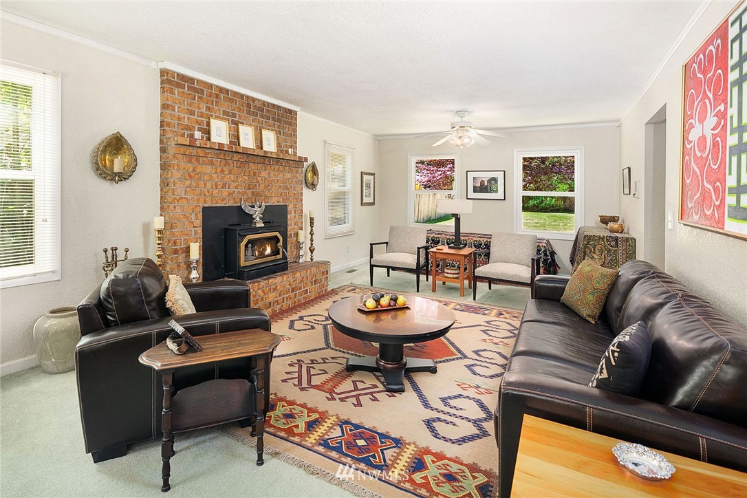 17905 Beall Road Southwest Vashon, WA 98070 - Photo 3 of 20 a living room with furniture a fireplace and a large window