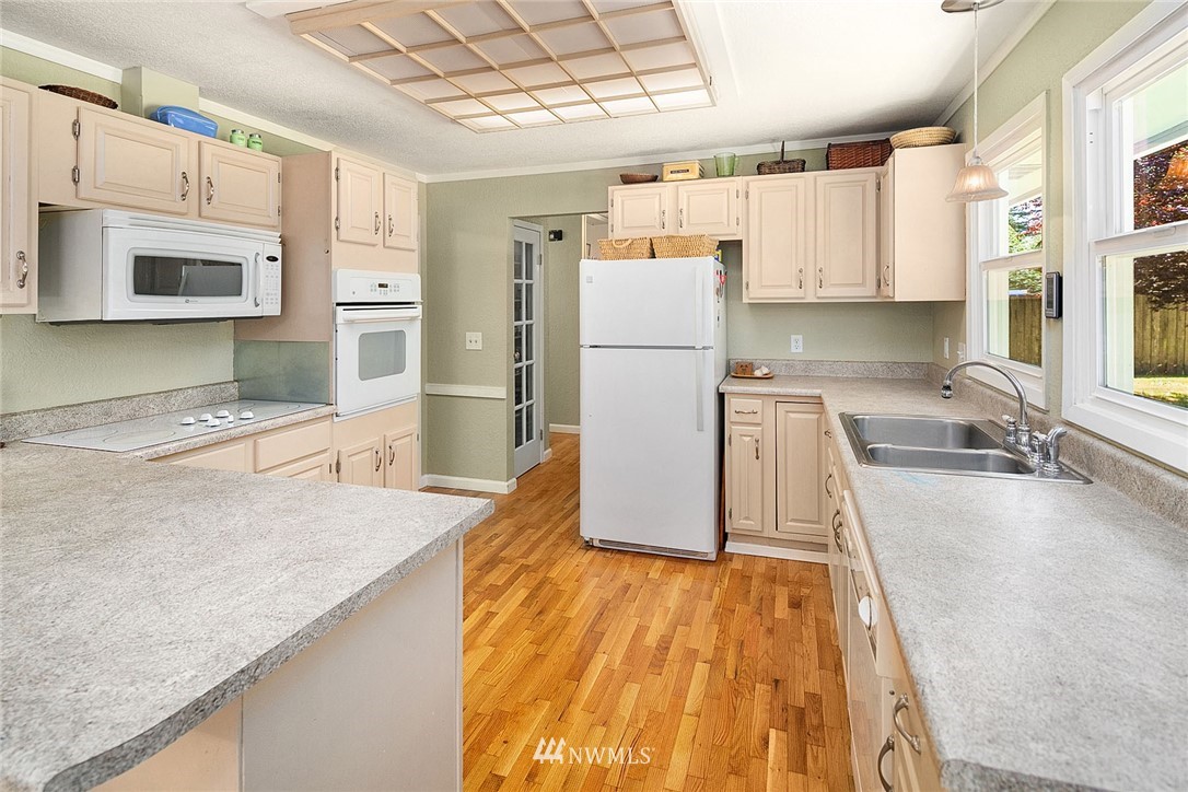 17905 Beall Road Southwest Vashon, WA 98070 - Photo 8 of 20 a kitchen with a sink a refrigerator and a stove top oven