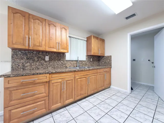 a kitchen with stainless steel appliances granite countertop a sink and cabinets