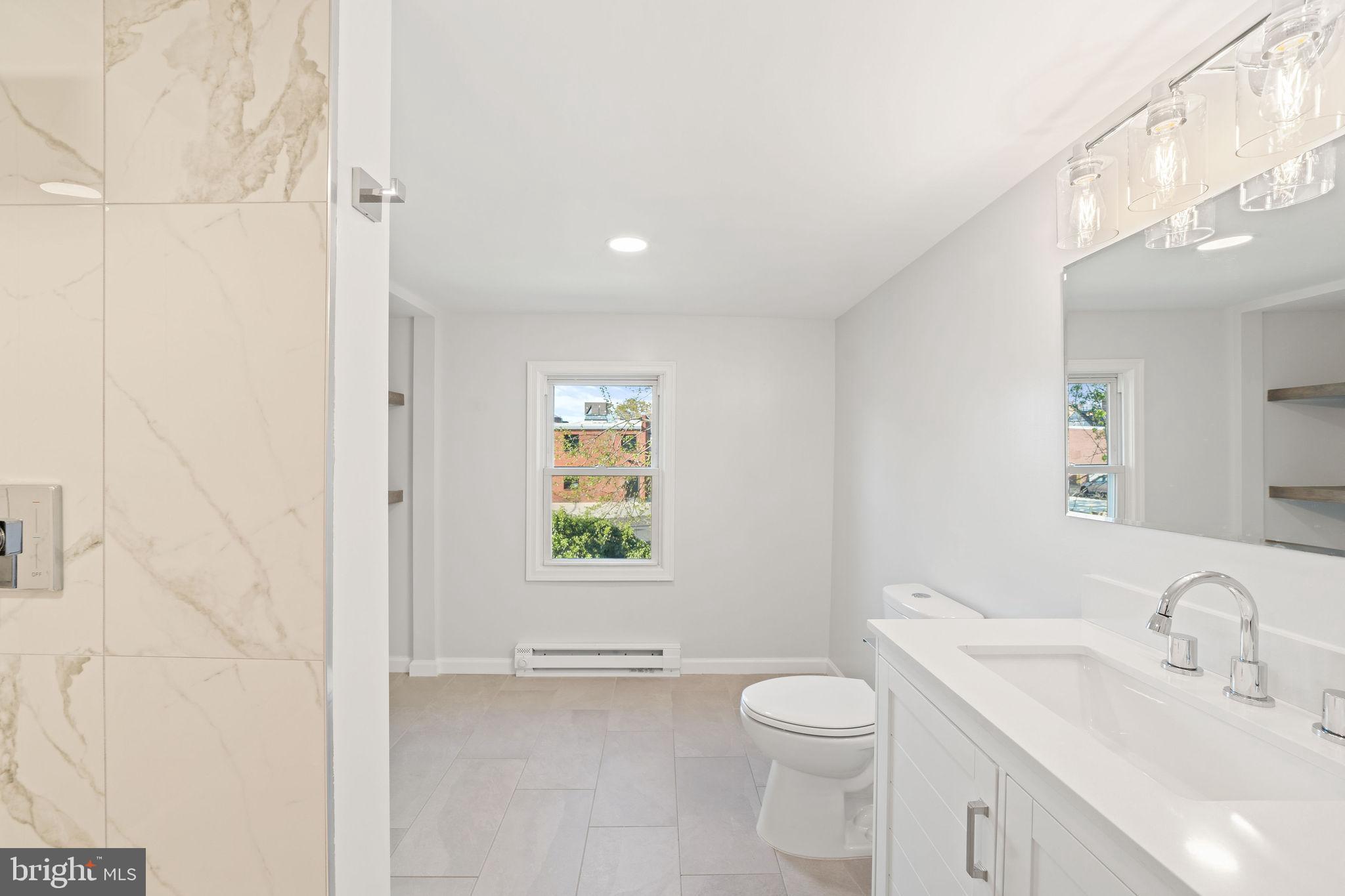 4 Walnut Street Salem, NJ 08079 - Photo 15 of 33 a bathroom with a toilet a sink a mirror and a window