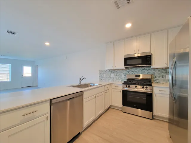 a kitchen with stainless steel appliances granite countertop a sink and a stove