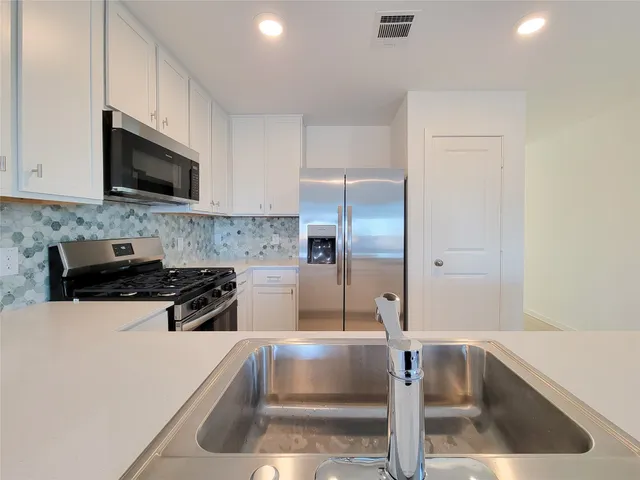 a kitchen with stainless steel appliances granite countertop a stove and a refrigerator