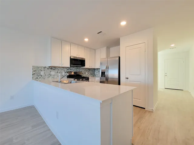 a kitchen with stainless steel appliances a refrigerator stove microwave and sink