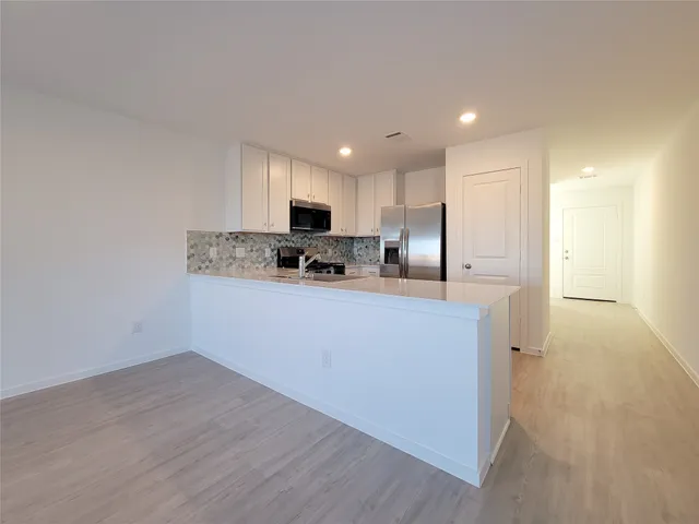 a kitchen with kitchen island a sink stainless steel appliances and cabinets