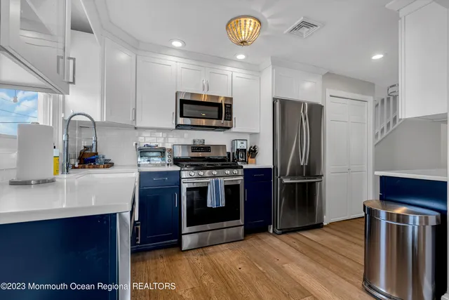 a kitchen with stainless steel appliances granite countertop a refrigerator stove and microwave