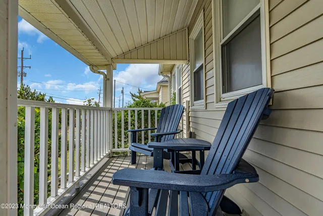 a view of a house with wooden deck and a barbeque