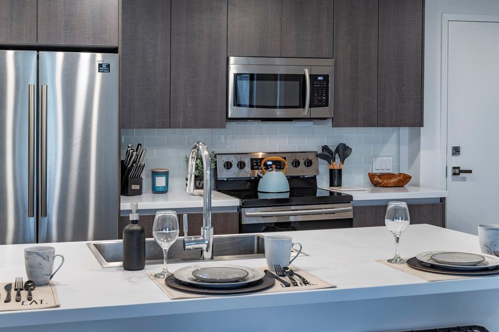 425-475 East Atlantic Boulevard, Unit 510 Pompano Beach, FL 33060 - Photo 23 of 35 a kitchen with a sink and microwave stove