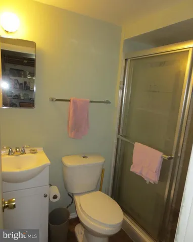 a white toilet sitting next to a bathroom sink and a mirror