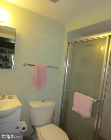 a white toilet sitting next to a bathroom sink and vanity