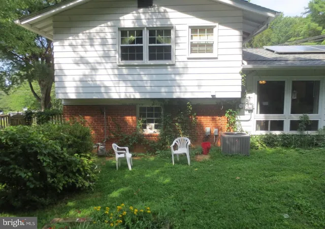 a view of a chair and table in backyard of the house