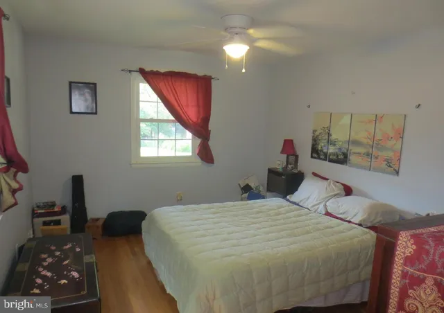 a bedroom with a bed and a dresser next to a window