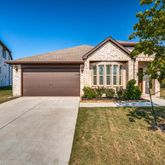 a view of a house with a yard and large tree
