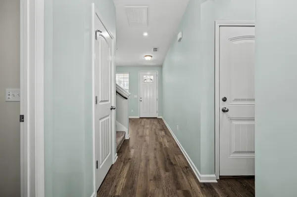a view of a hallway with wooden floor and staircase