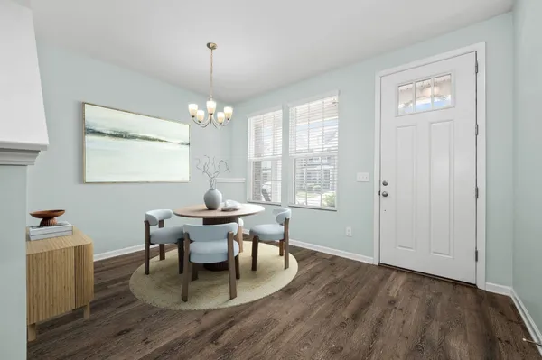 a dining room with wooden floor a chandelier a wooden table and chairs