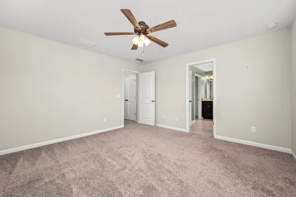 an empty room with closet and ceiling fan
