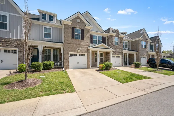 a front view of a house with a yard and potted plants
