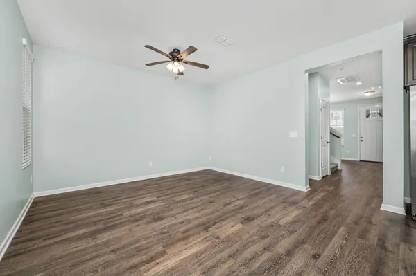 a view of a room with wooden floor and a ceiling fan