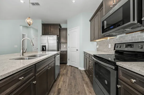 a kitchen with stainless steel appliances a sink dishwasher stove microwave and cabinets