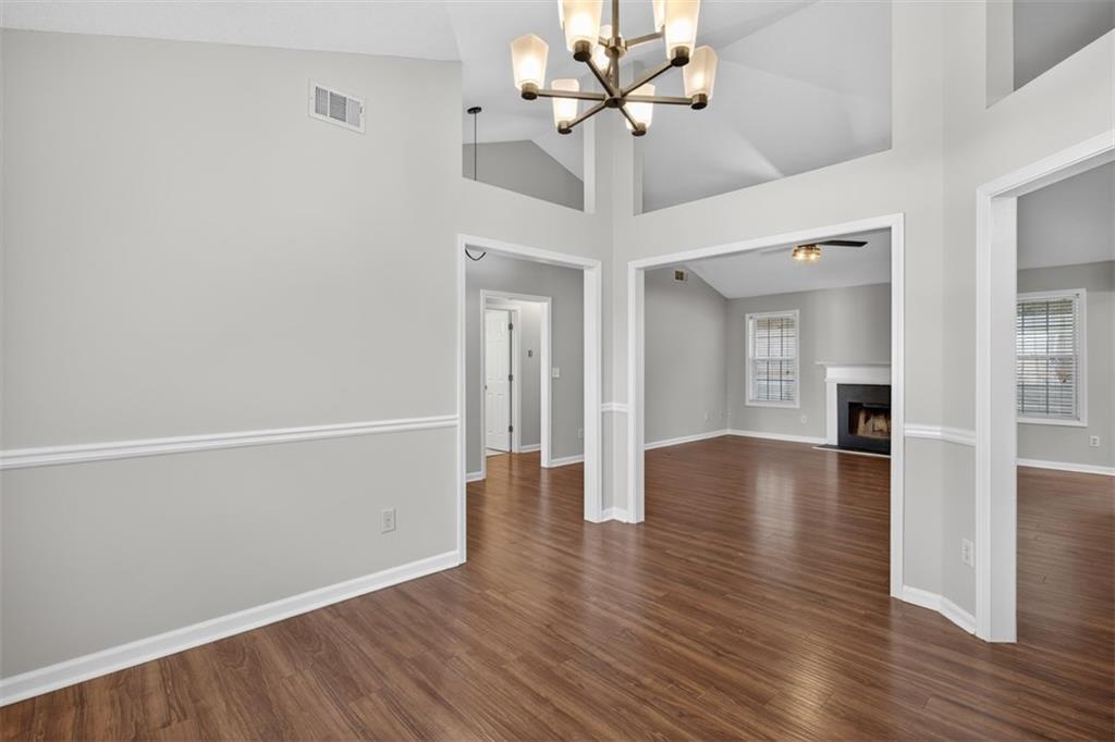 5683 Riverside Walk Drive Northeast Sugar Hill, GA 30518 - Photo 11 of 42 a view of an empty room with wooden floor and a ceiling fan