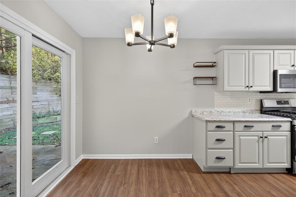 5683 Riverside Walk Drive Northeast Sugar Hill, GA 30518 - Photo 13 of 42 a view of kitchen with wooden floor electronic appliances and windows