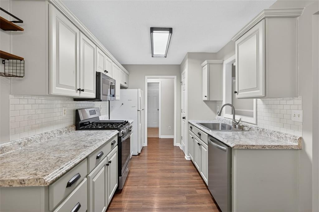 5683 Riverside Walk Drive Northeast Sugar Hill, GA 30518 - Photo 15 of 42 a kitchen with stainless steel appliances granite countertop a sink stove and refrigerator