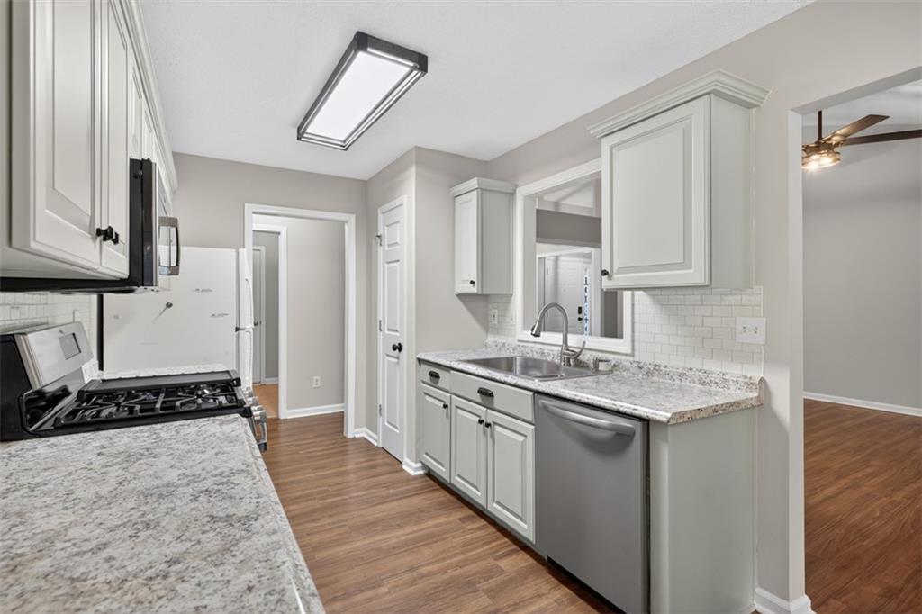 5683 Riverside Walk Drive Northeast Sugar Hill, GA 30518 - Photo 16 of 42 a kitchen with stainless steel appliances granite countertop a sink stove and cabinets