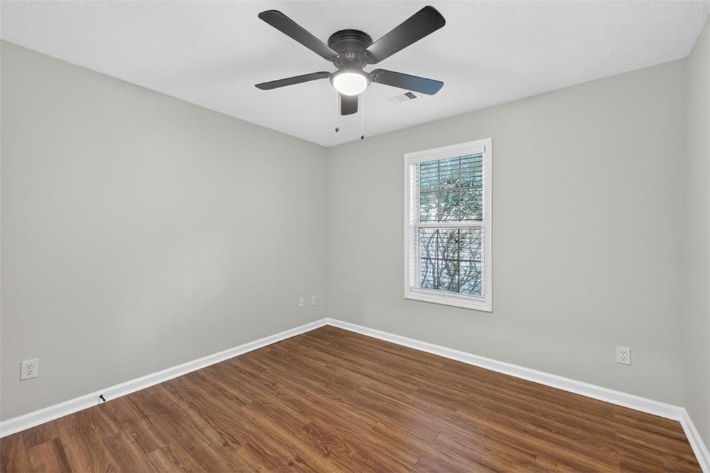 5683 Riverside Walk Drive Northeast Sugar Hill, GA 30518 - Photo 21 of 42 a view of an empty room with window and wooden floor