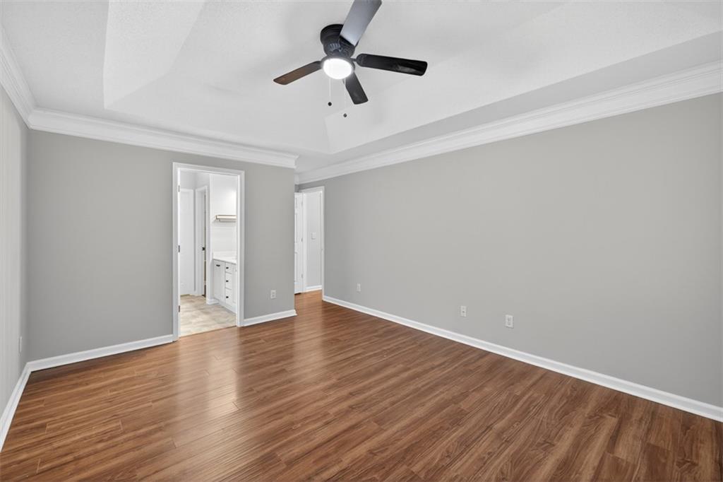 5683 Riverside Walk Drive Northeast Sugar Hill, GA 30518 - Photo 29 of 42 an empty room with wooden floor ceiling fan and window