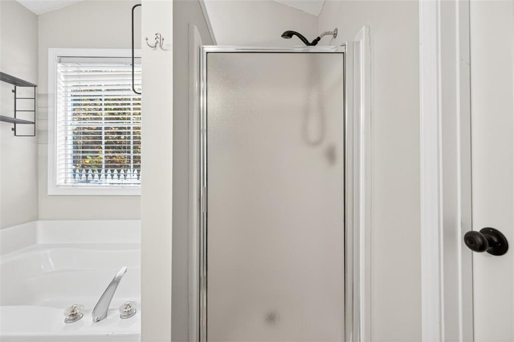 5683 Riverside Walk Drive Northeast Sugar Hill, GA 30518 - Photo 33 of 42 a bathroom with a bathtub and a shower