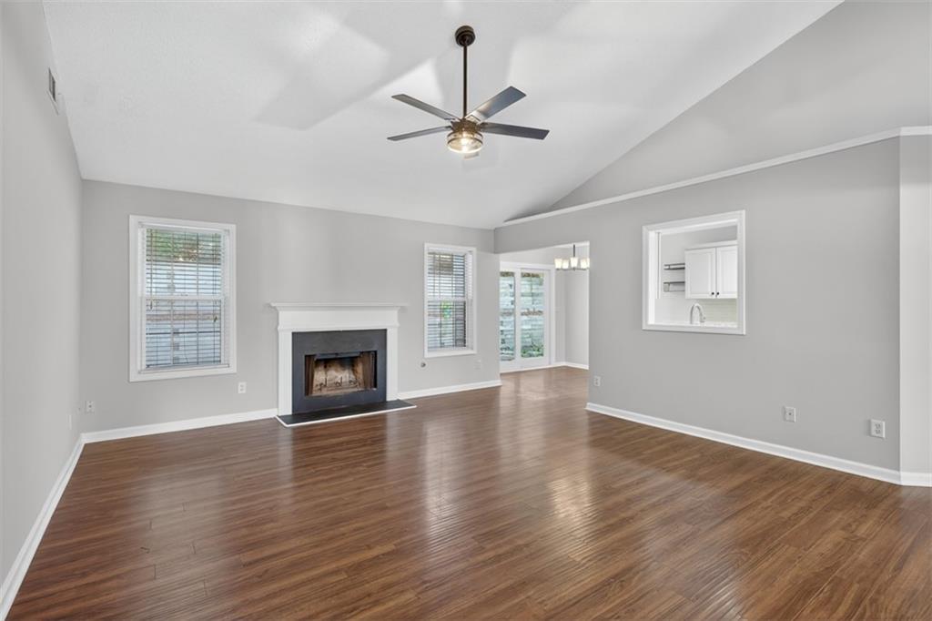 5683 Riverside Walk Drive Northeast Sugar Hill, GA 30518 - Photo 4 of 42 a view of an empty room with wooden floor fireplace and a window
